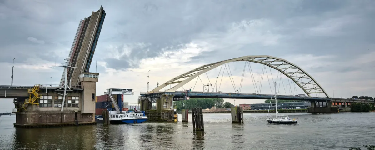 Zijaanzicht van de papendrechtse brug. De brug staat open voor een schip.